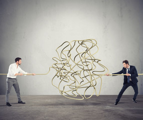 Businessmen try to solve a tangled rope. Concept of partnership