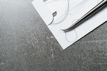 Curved needle holder for suture surgery. Nylon surgical thread.