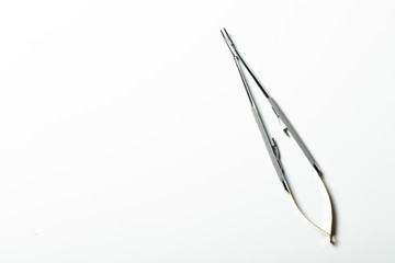 Curved needle holder for suture thread. White background with space for text.