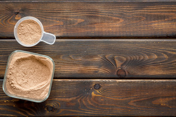 Nutrition for workout with protein cocktail powder on wooden background top view mockup