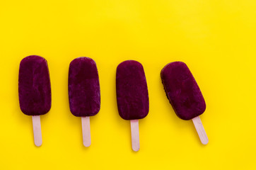 Homemade blueberry popsicle on the yellow