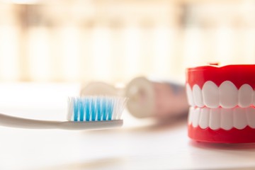 Close up Denture with toothpaste Toothbrush on blurred background.Metaphor for oral, dentures jaw toothy healthcare protect.