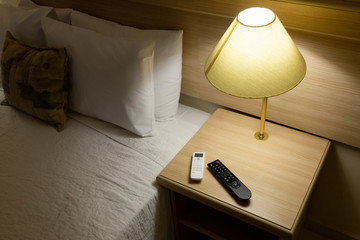 Hotel room, bed, pillows, lamp and controllers