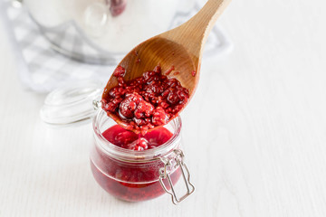 freshly made raspberry marmalade in wooden spoon