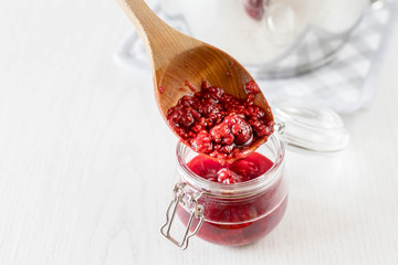 freshly made raspberry marmalade in wooden spoon