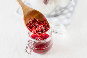 freshly made raspberry marmalade in wooden spoon