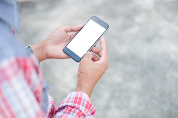Cropped shot view of man hands holding smart phone with blank copy space screen for your text message or information content, female reading text message on cell telephone during in urban setting. 