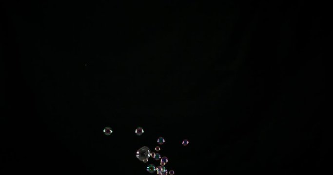 Large and clear water bubbles floats over a black background
