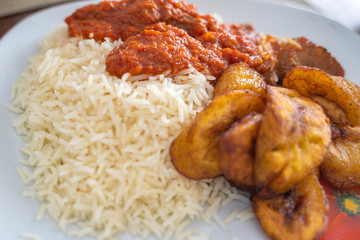 Nigerian Rice and Plantain - Dodo - with spicy Tomato Pepper Stew © primestockphotograpy