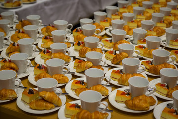 Row of croissants, cakes and a cup of coffee snacks for seminars