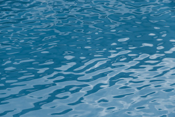 Blue swimming pool edge with refection of water ripple
