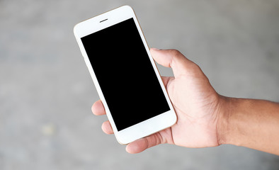 Cropped shot view of man hands holding smart phone with blank copy space screen for your text message or information content, female reading text message on cell telephone during in urban setting. 