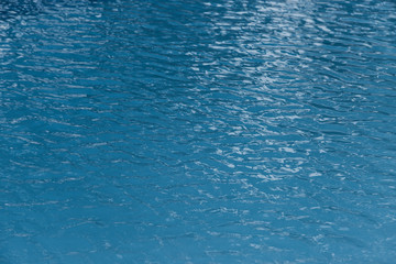 Blue swimming pool edge with refection of water ripple