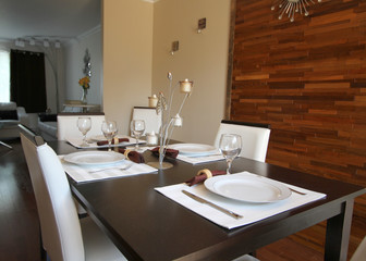 Table setting in dining room with wood panel on wall