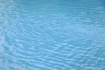 Blue swimming pool edge with refection of water ripple