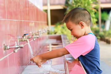 Soft focus, Health care and kid concept. Asian child boy washing his hands before eating food and after play the toys at the washing bowl. A boy aged of 5 years old.