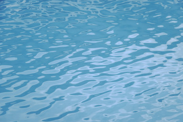 Blue swimming pool edge with refection of water ripple