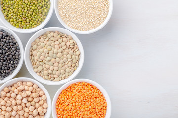 Different types of legumes in small pussies on a white background