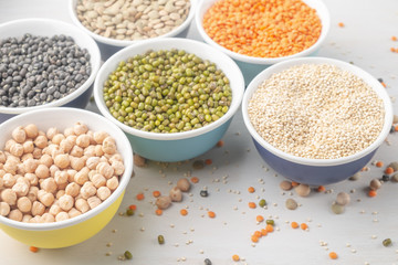 Different types of legumes in small pussies on a white background