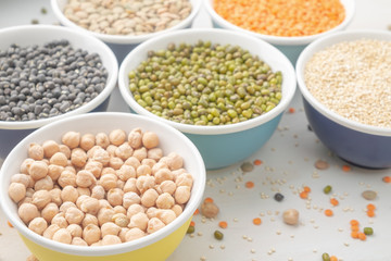 Different types of legumes in small pussies on a white background