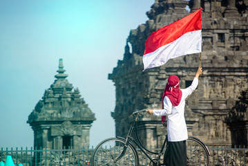 Asian Hijab flapper Indonesian flag in bicycle, Indonesia independence day