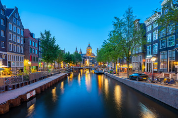 Naklejka premium Saint Nicholas Church with Amsterdam skyline at night in Netherlands
