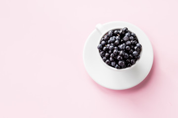 Ripe blueberries in Cup on pstel background. beautiful summer harvest season concept. Fresh blueberries. Top view.Copy space.Summer and healthy food concept.