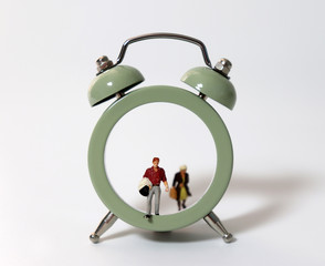 Miniature people walking out of the clock.
