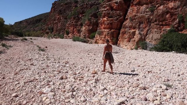 Woman walking in arid outback Australian gorge 