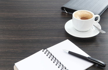 cup of coffee and pen on a notebook