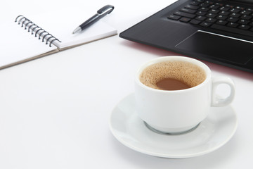 cup of coffee and pen on laptop