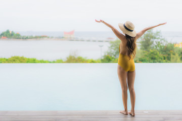 Portrait asian beautiful young woman happy smile relax around outdoor swimming pool in holiday vacation
