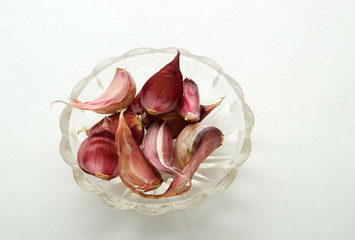 Garlic in a plate on a white background. Garlic cloves top view.