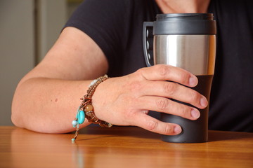Closeup of woman's hand holding coffee cup