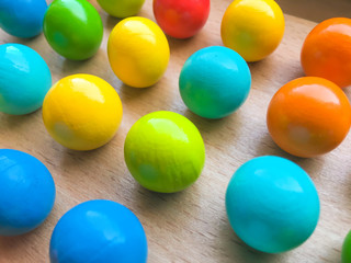 colored toy balls on a wooden table. educational toys for children. background for business