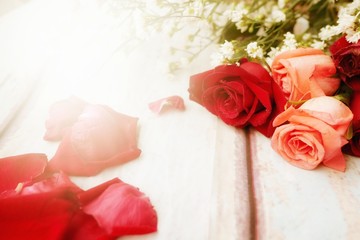 Red roses, old rose or salmon color, are on wooden background. Background for sweet moment or Valentine's day.