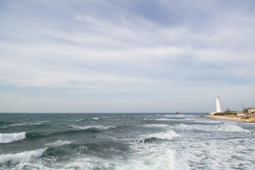 Lighthouse stands on the beach in the evening