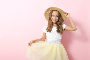 Little cheerful smiling girl in fashionable clothes on a colored background. Children's clothing, children's fashion