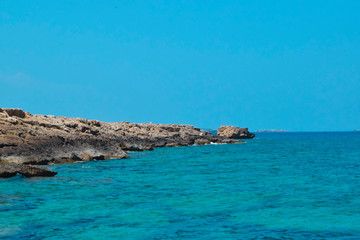 Fototapeta premium rocky coastline on turquoise sea background 