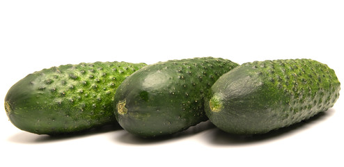 green cucumbers lie on a white background