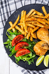 Grilled chicken drumsticks with french fries and vegetables