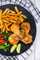 Grilled chicken drumsticks with french fries and vegetables