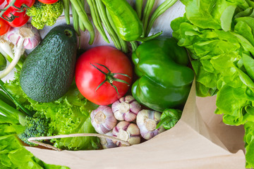 Healthy food in paper bag of different  vegetables on white background. Top view.