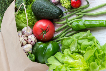 Healthy food in paper bag of different  vegetables on white background. Top view.