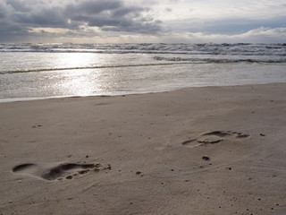 Wet sand barefoot prints stormy Gulf coast beach
