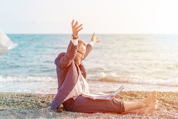 Businessman working with computer on the beach