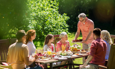 leisure, holidays and people concept - happy family having festive dinner or summer garden party