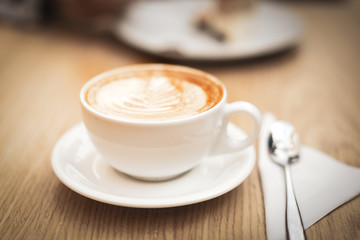 Hot coffee cappuccino latte art on wooden background