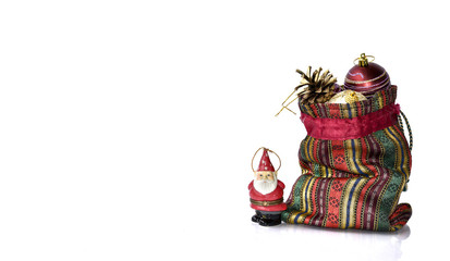 Santa Claus figurine stands guard over a bag full of Christmas decorations.