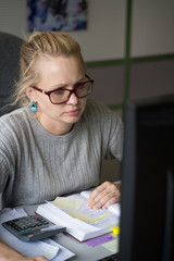 The girl in glasses sitting  under paper work in the office